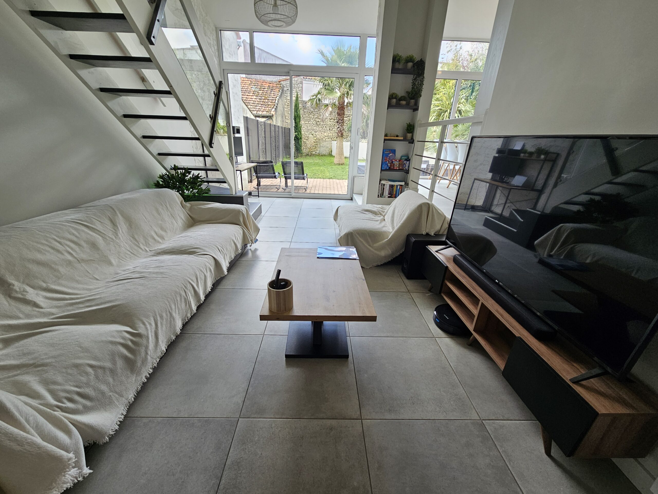 Après l'entrée avec la chambre 1 et la salle de bain du RDC, nous arrivons dans le salon donnant sur un magnifique jardin.
